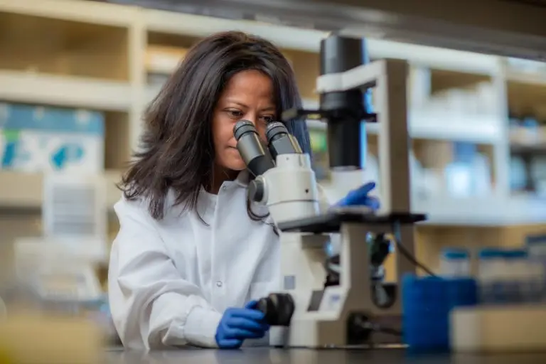 Photo of LJI Professor Sujan Shresta using a microscope