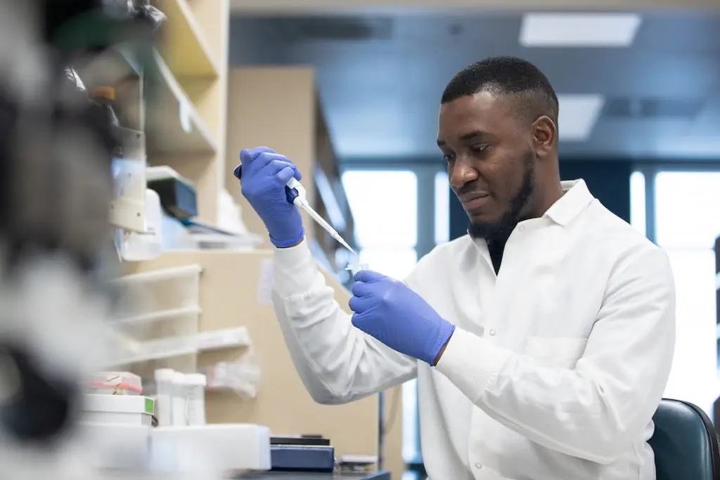 Photo of Onyeka Chukwudozie using a pipette in a lab setting