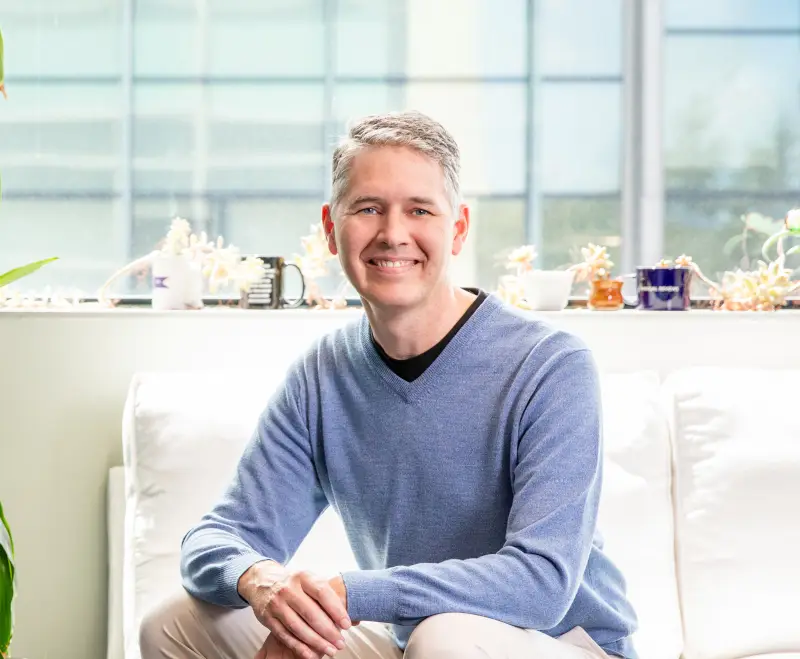 Portrait photo of Shane Crotty, Ph.D. He is sitting and smiling at the camera