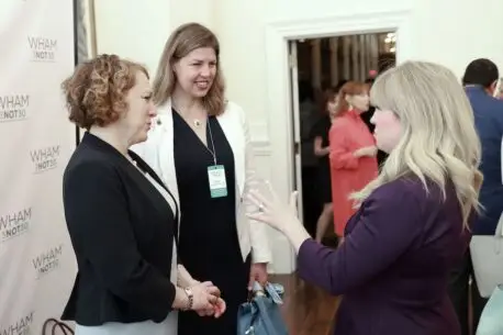 Event photo showing three women talking with each other