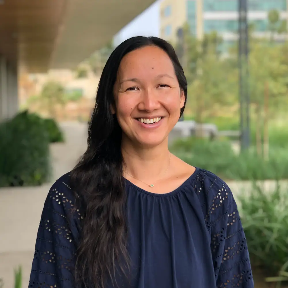 Photo portrait of Sydney Ramirez, M.D., Ph.D. Ramirez is standing outside the LJI building and smiling at the camera