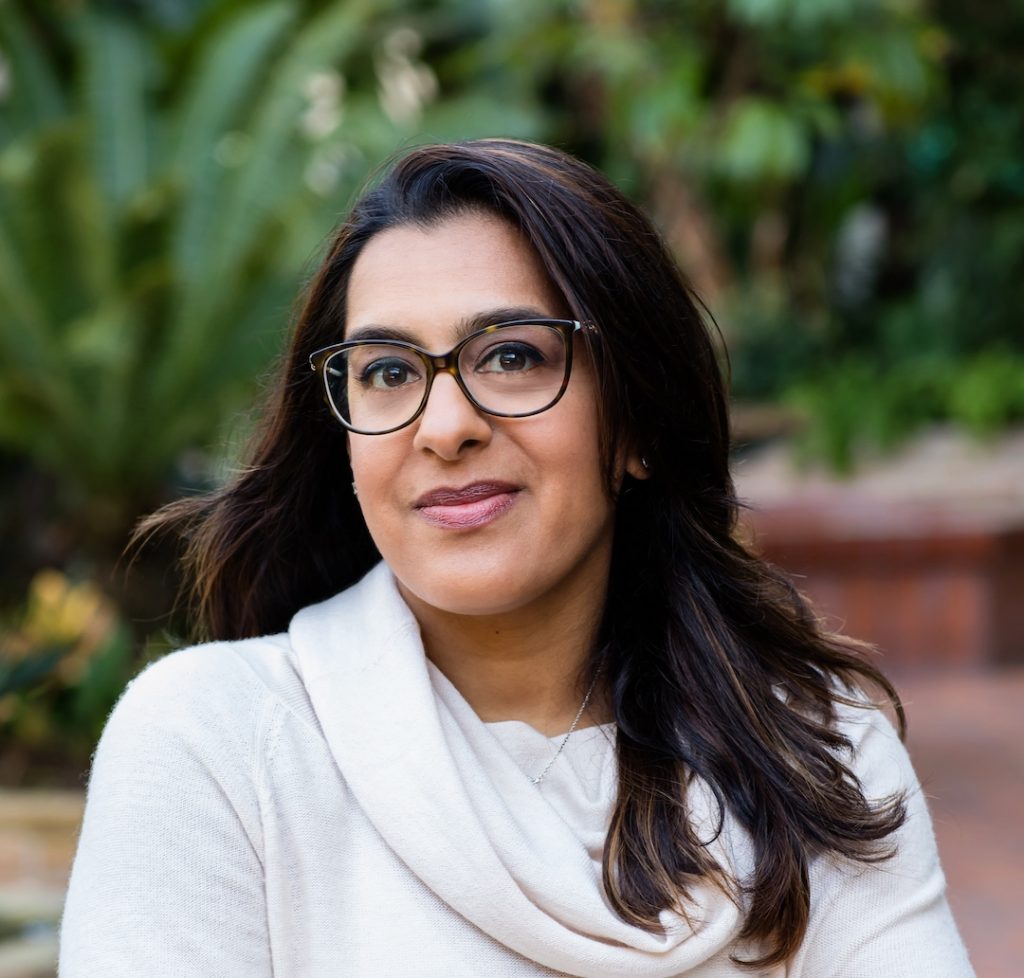 Portrait photo of Sharma. She is standing outside and looking into camera