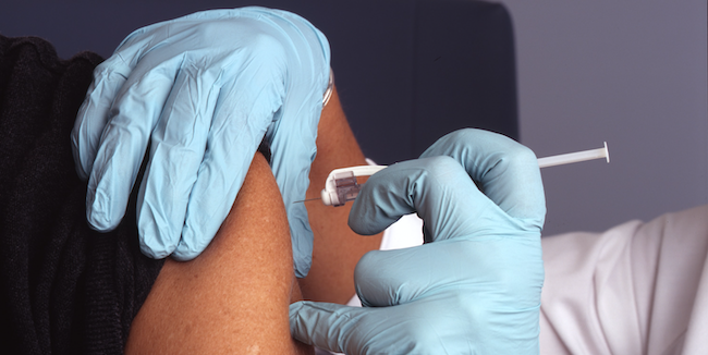 Photo of a person getting a vaccine needle in their arm