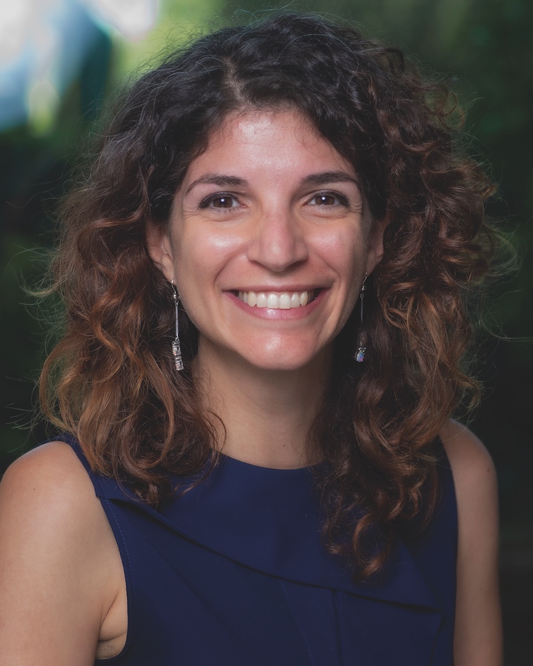 Portrait photo of Dr. Grifoni. She is wearing blue and smiling at the camera