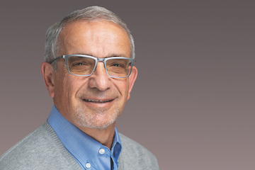 Portrait photo of Dr. Altmon. He is wearing glasses and smiling at the camera