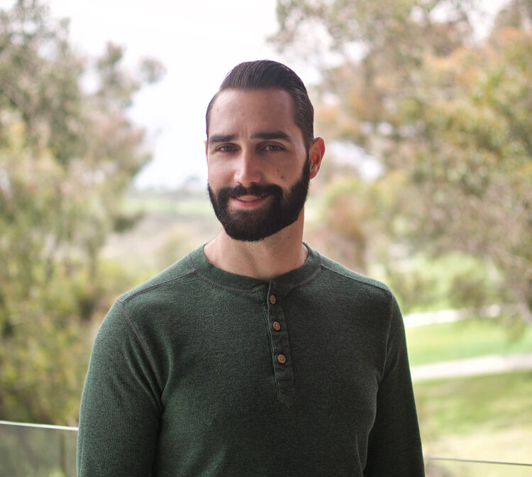 Portrait photo of Timothy Baffi, Ph.D. He is standing outside and smiling at the camera