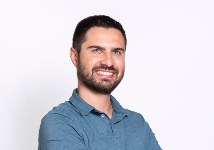 Photo portrait of Marco Orecchioni. Orecchioni is looking at the camera and smiling