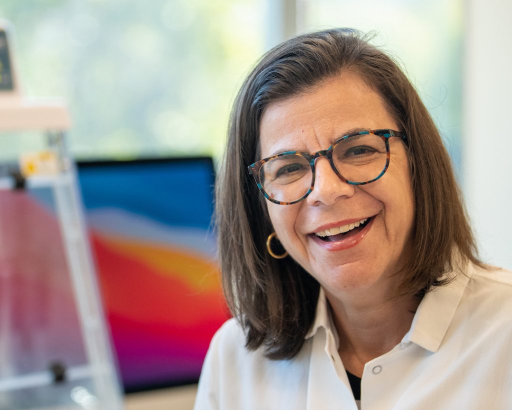 A scientist smiles at the camera.