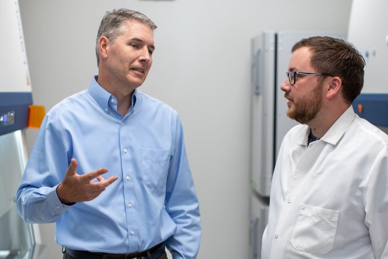 Phoo of Crotty and Sutton talking in a laboratory setting