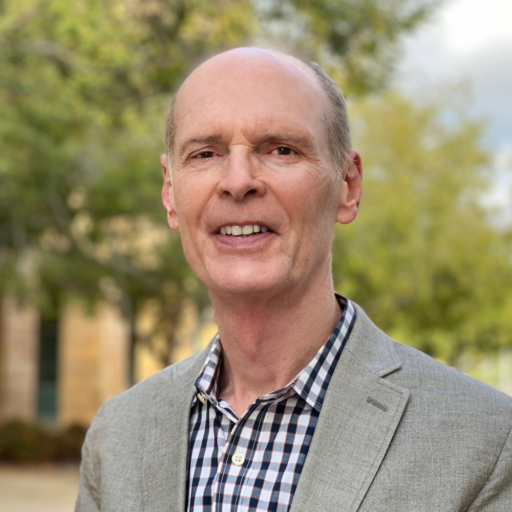 Photo portrait of Joel Martin. He is standing outside and smiling at the camera